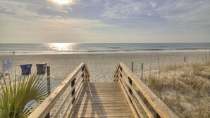 A wooden boardwalk leading to a beach with a clear sky and sun. - Charming 2BR for 6! Steps to Beach! MBR 346A (Myrtle Beach)