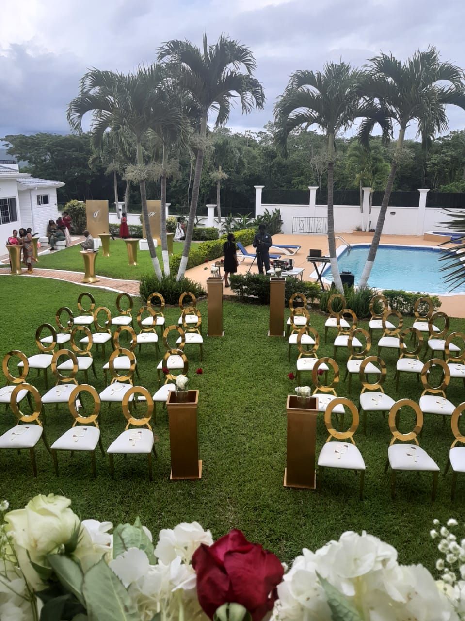 Montagem de casamento ao ar livre com fileiras de cadeiras e uma piscina ao fundo.
