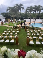 Montaje para una boda al aire libre con filas de sillas y una piscina al fondo.