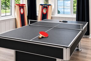 A ping pong table with a paddle, two clocks, and a window with curtains. - Video Game Hub, Hot Tub, PS5, Xbox, Switch, Pool Table, Air Hockey, Fire Pit (Valdosta)
