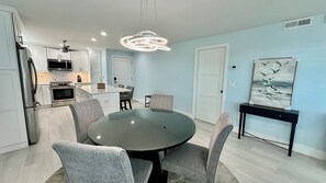 A modern kitchen with white cabinets, stainless steel appliances, and a central island with seating. - Tarpon Beach 108: Panoramic water views, 2nd floor, west corner - Sunsets! (Sanibel)