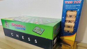 Une boîte contenant un jeu d’échecs, avec un motif vert et noir, posée sur une surface en bois.