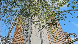 Un immeuble de grande hauteur doté de nombreux balcons, d’un escalier et d’une enseigne indiquant le nom « MABUHA ».