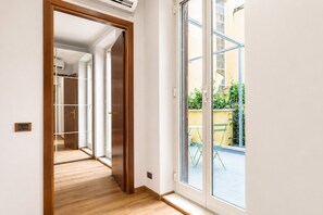 A hallway leading to a glass door with a view of an outdoor area. - Elegantis Campo Marzio Penthouse With Terrace | Spanish Steps, Trevi & Pantheon (Roma)