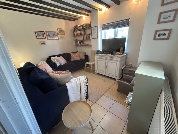A living room with a sofa, a television, a cabinet, and a small table.