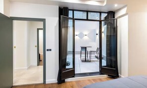 A modern interior with a sliding glass door leading to an outdoor seating area. - AN EXCEPTIONAL AUTHENTIC PARISIAN CHARM WITH PRIVATE COURTYARD -SAINT GERMAIN (Paris)