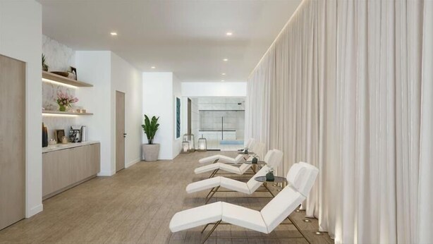Un salon moderne comprenant un coin cuisine, un espace détente avec des chaises blanches et une grande fenêtre agrémentée de rideaux.