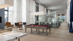 A modern hotel lobby with a pool table, comfortable seating, and a glass display case. - near Bayfront Park Deluxe Room , Pet - friendly (Miami)