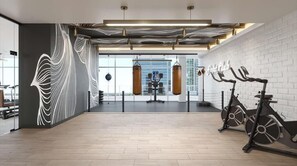A spacious gym with exercise equipment, a punching bag, and a wall mural. - Prime Miami Worldcenter with City Views! (Miami)