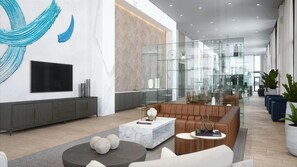 A modern lobby with a large TV, seating area, and a glass partition. - Deluxe 1BR near Bayfront Park &  Kaseya Center (Miami)