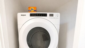 Dos lavadoras Whirlpool apiladas en un pasillo estrecho.
