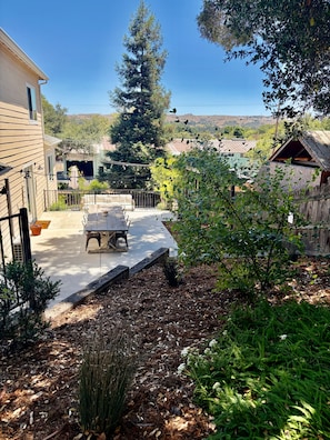 A backyard with a patio, a wooden fence, and a view of the surrounding landscape. - Superb 3-bedroom home in peaceful Atascadero (Atascadero)