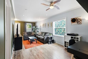 Un salon avec un canapé, une table basse et un ventilateur de plafond.