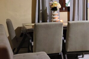 A dining area with a table set for two, a vase with flowers, and a candle on the table. - Just a 5-minute drive from the lagoon! Casa Mamey, perfect for families (Bacalar)