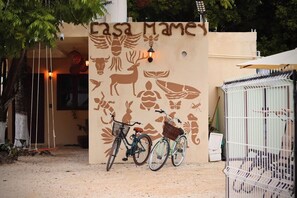 A building entrance with a wall mural featuring wildlife and a bicycle parked in front. - Just a 5-minute drive from the lagoon! Casa Mamey, perfect for families (Bacalar)