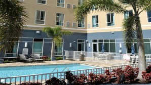 A hotel with a swimming pool, multiple balconies, and palm trees. - Accessible 1 King Studio w/ Hot Breakfast + Pool (St. Petersburg)