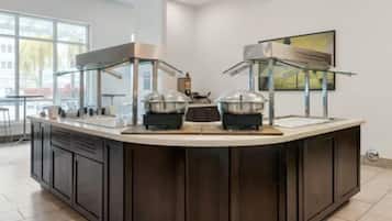 A modern kitchen with a central island, equipped with a stove, a sink, and a refrigerator.
