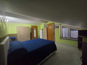 A room with a bed, wardrobe, and a window with blinds. - Vrbo Property (Riposto)
