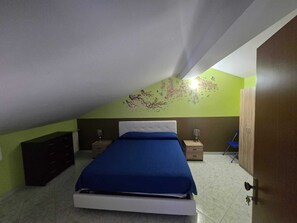 A bedroom with a bed, a dresser, a chair, and a wardrobe. - Vrbo Property (Riposto)