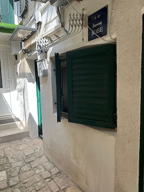 A narrow street with a building featuring a closed shutter and a sign reading 'SOBE'. - The Heart of Old Town (Split)
