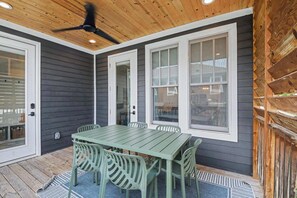 A covered patio area with a table and chairs, wooden ceiling, and large windows. - 4BR Escape for 12, East Nash Walkable Location! (Nashville)
