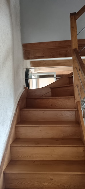 A wooden staircase with a metal handrail and a glass door at the top. - Charming stone house with a garden – Finistère, near the sea (Quéménéven)