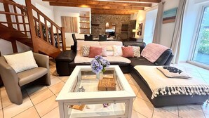 Una sala de estar moderna con una mesa de centro de vidrio, sofás de cuero y una chimenea de piedra.