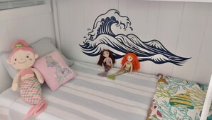 A bunk bed with a decorative wave design on the wall, plush toys, and a striped bedspread. - Peaceful 1-bedroom cabin in adorable Moclips perfect for relaxing (Moclips)