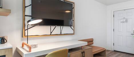 A modern room with a desk, chair, and a large mirror.