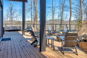 A wooden deck with outdoor seating, including chairs and a sofa, and a fire pit. - Rockhaus-Cliffside Dome Sauna/Hot Tub/Tremblant (La Conception)