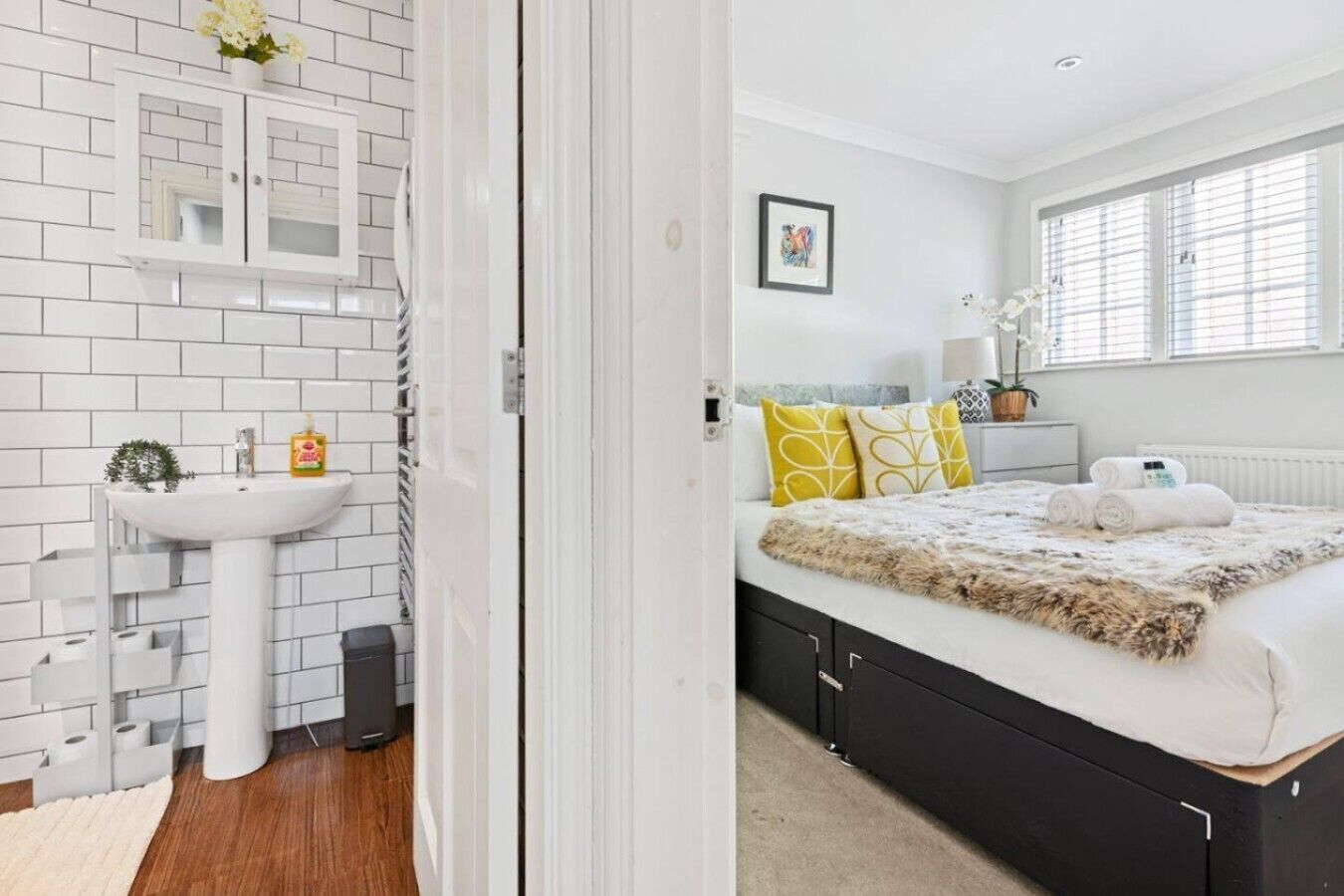 A modern bathroom with a white sink, toilet, and storage cabinet.