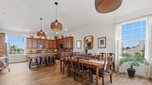 A spacious kitchen with wooden cabinets, a central island, and pendant lighting. - Tranquil Tides (New Smyrna Beach)