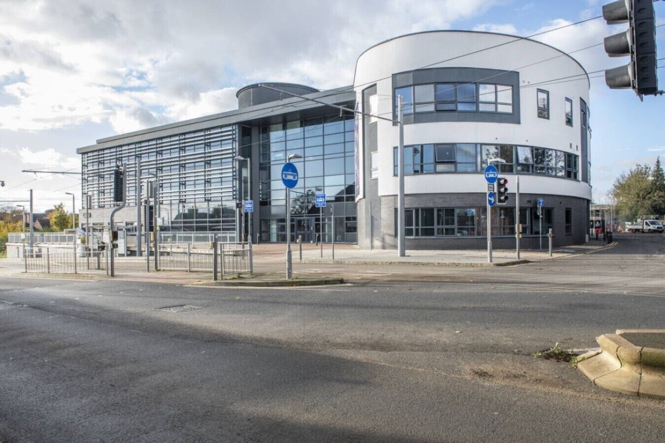 Un bâtiment moderne doté d’une façade en verre et d’une section incurvée.