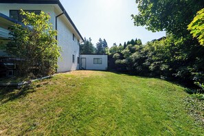 A modern house with a well-maintained lawn and a small garden area. - East Abbotsford Spanish Villa (Abbotsford)