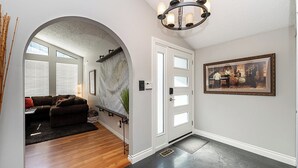 A hallway with a wooden floor, a white door, and a framed picture on the wall. - East Abbotsford Spanish Villa (Abbotsford)