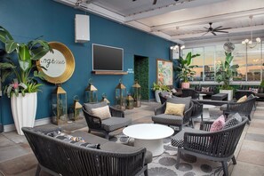 A lounge area with wicker furniture, a white round table, and potted plants. - Modern Stay in Downtown New Orleans Near the Quarter l 2 Units (New Orleans)