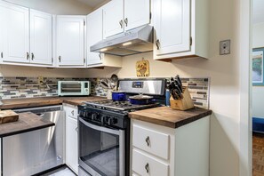 A kitchen with white cabinets, a microwave, a stove, and a dishwasher. - Large 2 Bed 2 Bath Condo in Prime West Knoxville/Bearden/Sequoyah Hills (Knoxville)