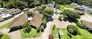 Vista aérea de una zona residencial con varias casas, una piscina y zonas verdes.