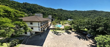 Un hotel con piscina, immerso nel verde e circondato da colline.