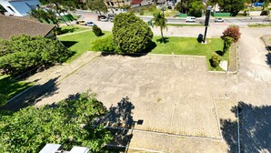 An aerial view of a residential area with a large open space, possibly a park or courtyard, surrounded by houses and greenery.