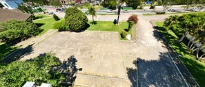 An aerial view of a residential area with a large open space, possibly a park or courtyard, surrounded by houses and greenery.