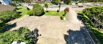 Vista aerea di una zona residenziale con un ampio spazio aperto, forse un parco o un cortile, circondato da case e vegetazione.