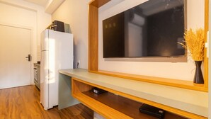 Una cuina moderna amb forn integrat, microones i taulell de fusta.