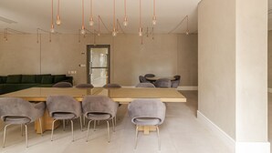 Una sala de reunions moderna amb una taula llarga, sis cadires i il·luminació penjant.