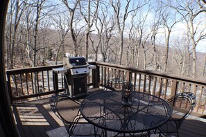 An outdoor deck with a grill, metal table, and chairs. - Ski in Style @ Sapphire Squirrel (Wintergreen Resort)