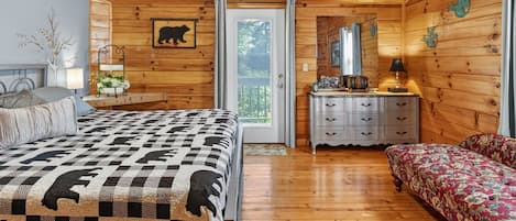 A wooden cabin bedroom with a bed, dresser, and a bench.