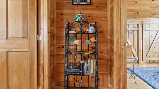 Un interior de madera con una estantería, una cita enmarcada y una lámpara decorativa.