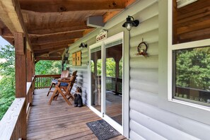 A cabin with a wooden deck, a welcome sign, and a bear decoration. - Scenic 4BR Retreat w/ Balcony & Mountain Views (Hartford)