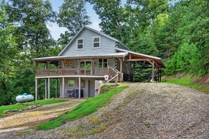 A two-story cabin with a covered porch and a gravel driveway. - Scenic 4BR Retreat w/ Balcony & Mountain Views (Hartford)