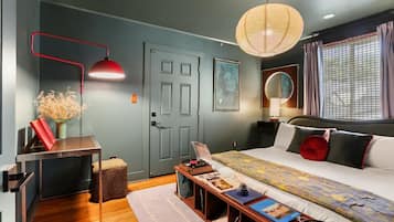 Een moderne slaapkamer met een bed, nachtkastje, lamp en een deur.
